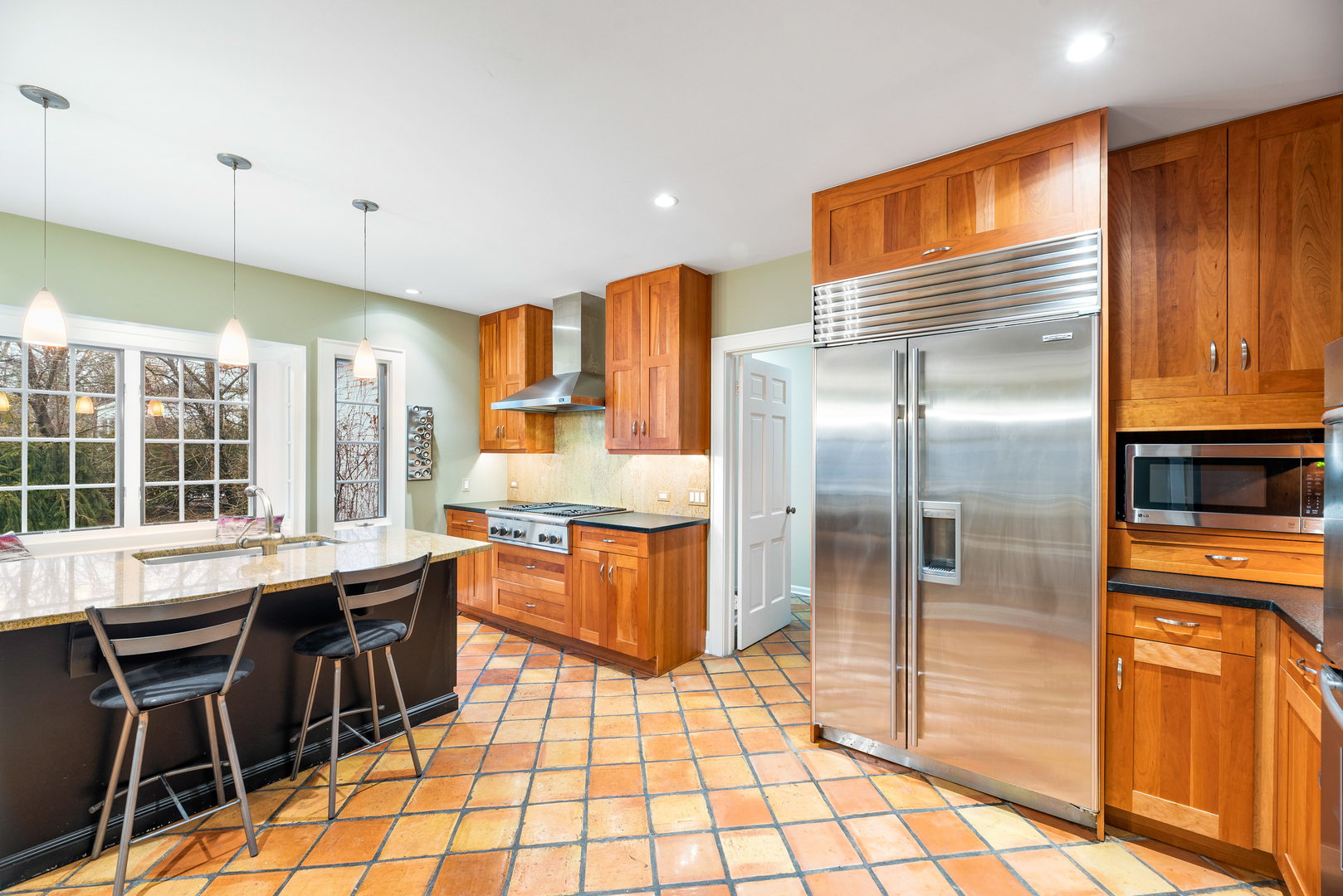 200 Hazel Avenue Glencoe, IL 60022 - Photo 8 of 51 a kitchen with stainless steel appliances granite countertop a stove a refrigerator a sink a dining table and chairs with wooden floor