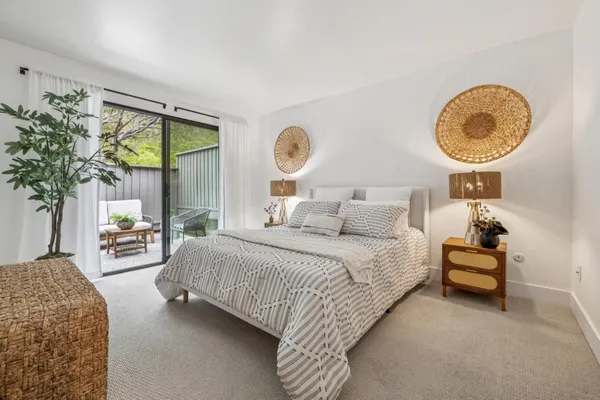 a bedroom with a large bed and a potted plant