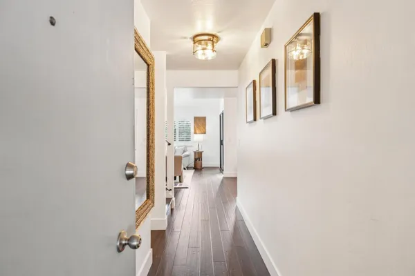 a view of a hallway with wooden floor and staircase