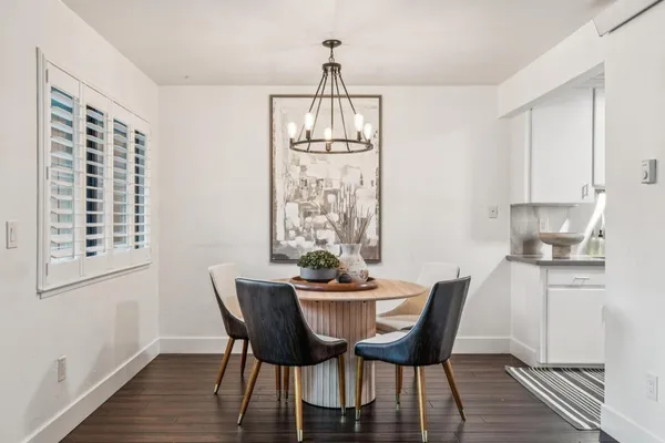 a dining room with furniture a chandelier and wooden floor