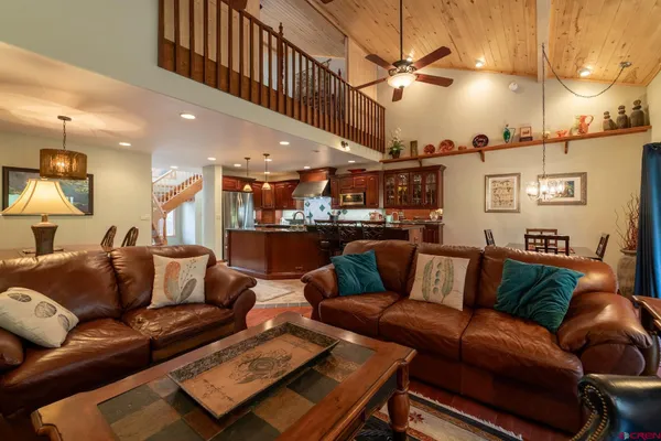a living room with furniture kitchen view and a chandelier