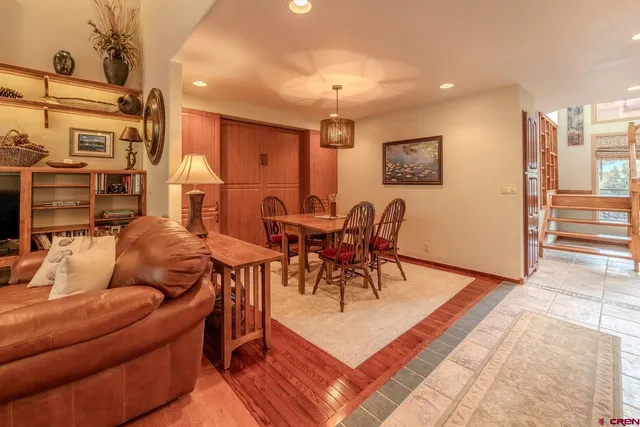 a living room with furniture a dining table and chairs with wooden floor
