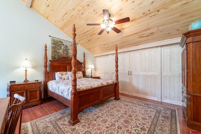 a bedroom with a bed and a mirror on a dresser