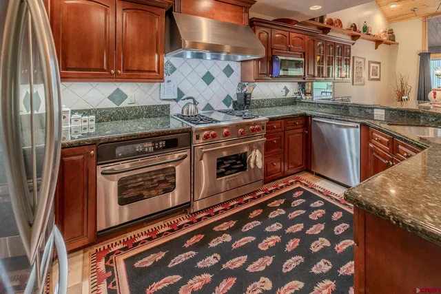 a kitchen with stainless steel appliances granite countertop a stove and a sink