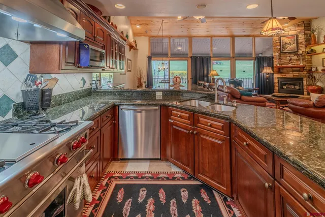 a kitchen with stainless steel appliances granite countertop a sink stove and cabinets