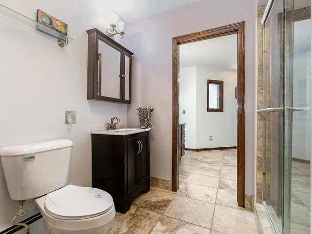 a bathroom with a toilet sink vanity and mirror