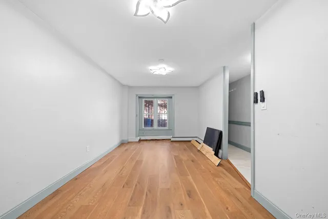 a view of a room with wooden floor fireplace and window