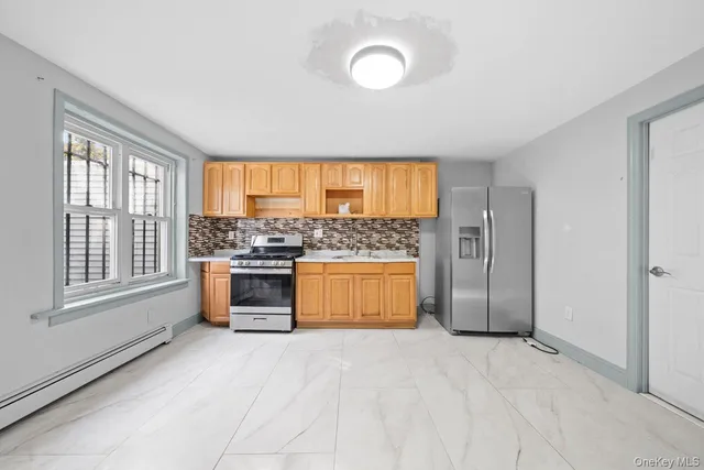a view of kitchen with stainless steel appliances granite countertop a stove and a refrigerator