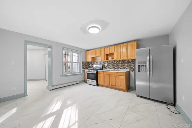 a large kitchen with a refrigerator and window