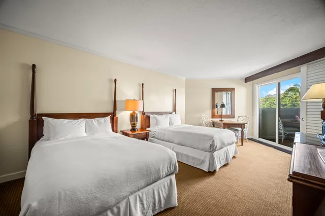 a bedroom with two beds and large window