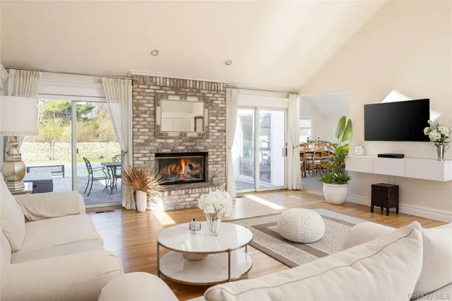 a living room with furniture a fireplace and a large window