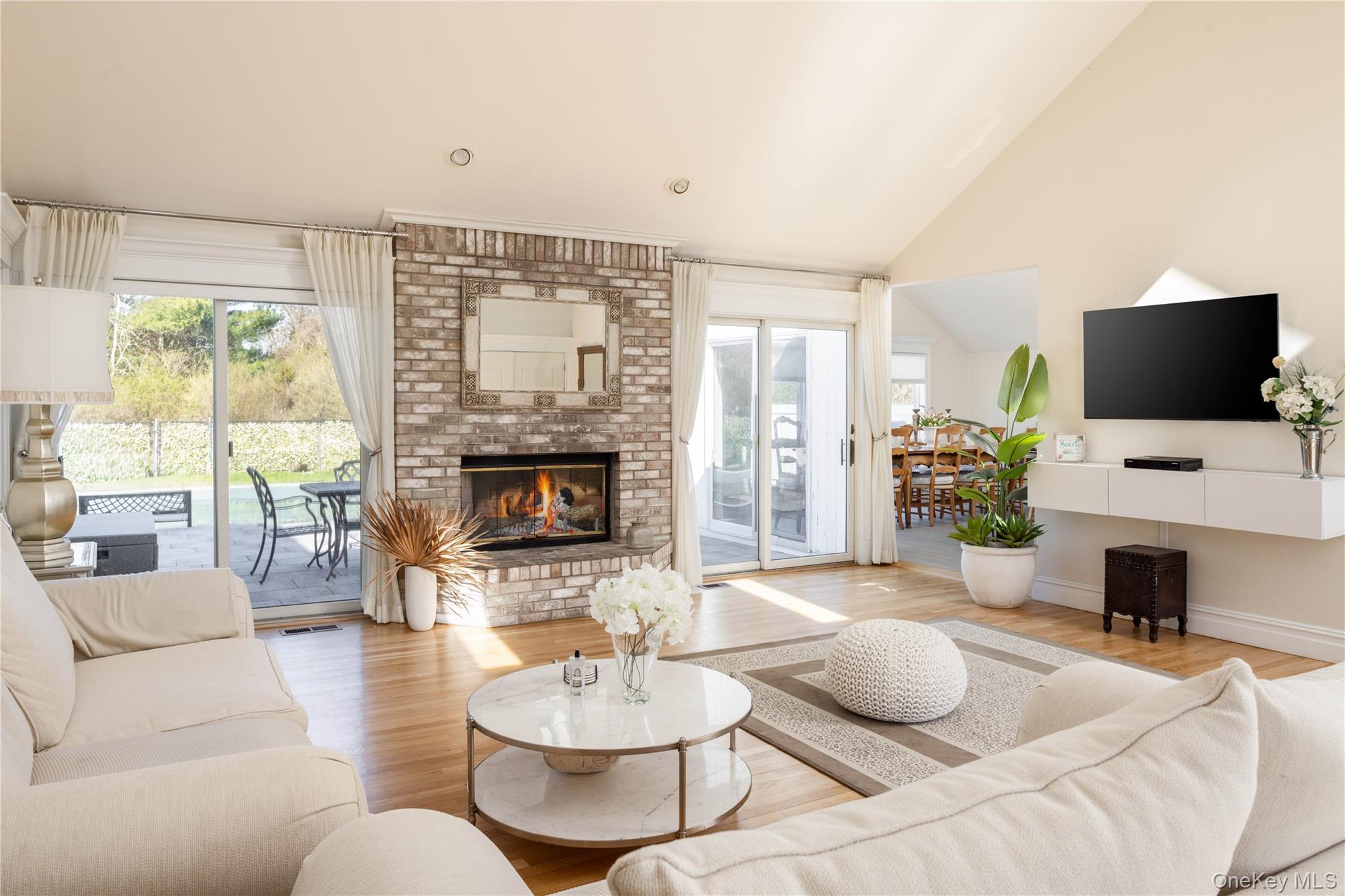 3 Clay Pit Road Remsenburg, NY 11960 - Photo 4 of 20 a living room with furniture a fireplace and a large window