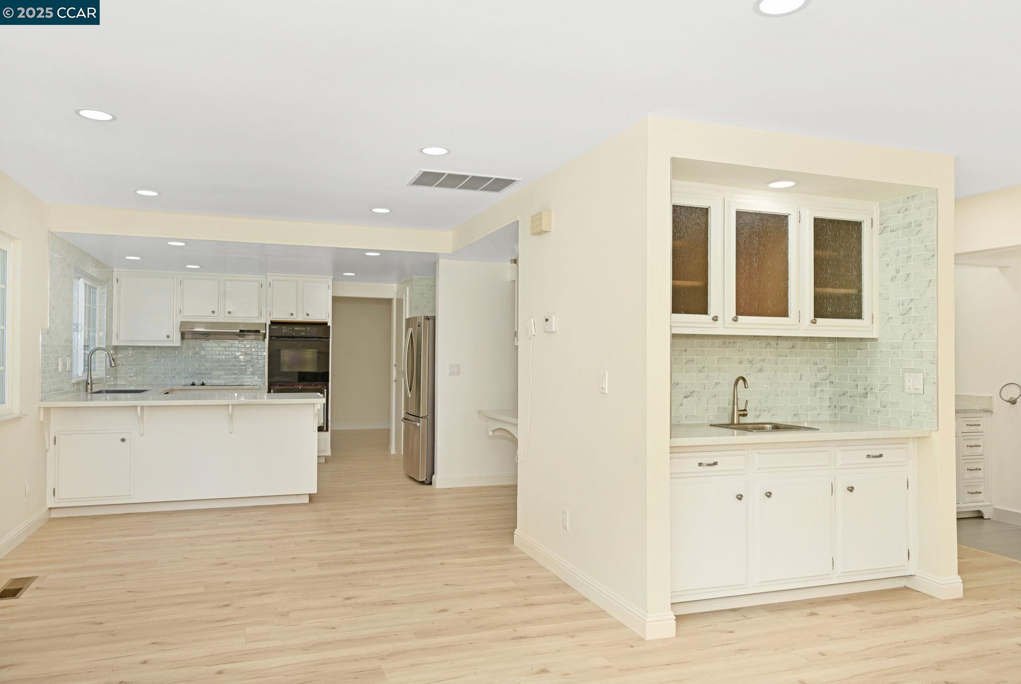 1181 Sunlight Circle Concord, CA 94518 - Photo 15 of 36 a large white kitchen with kitchen island a sink stainless steel appliances and cabinets