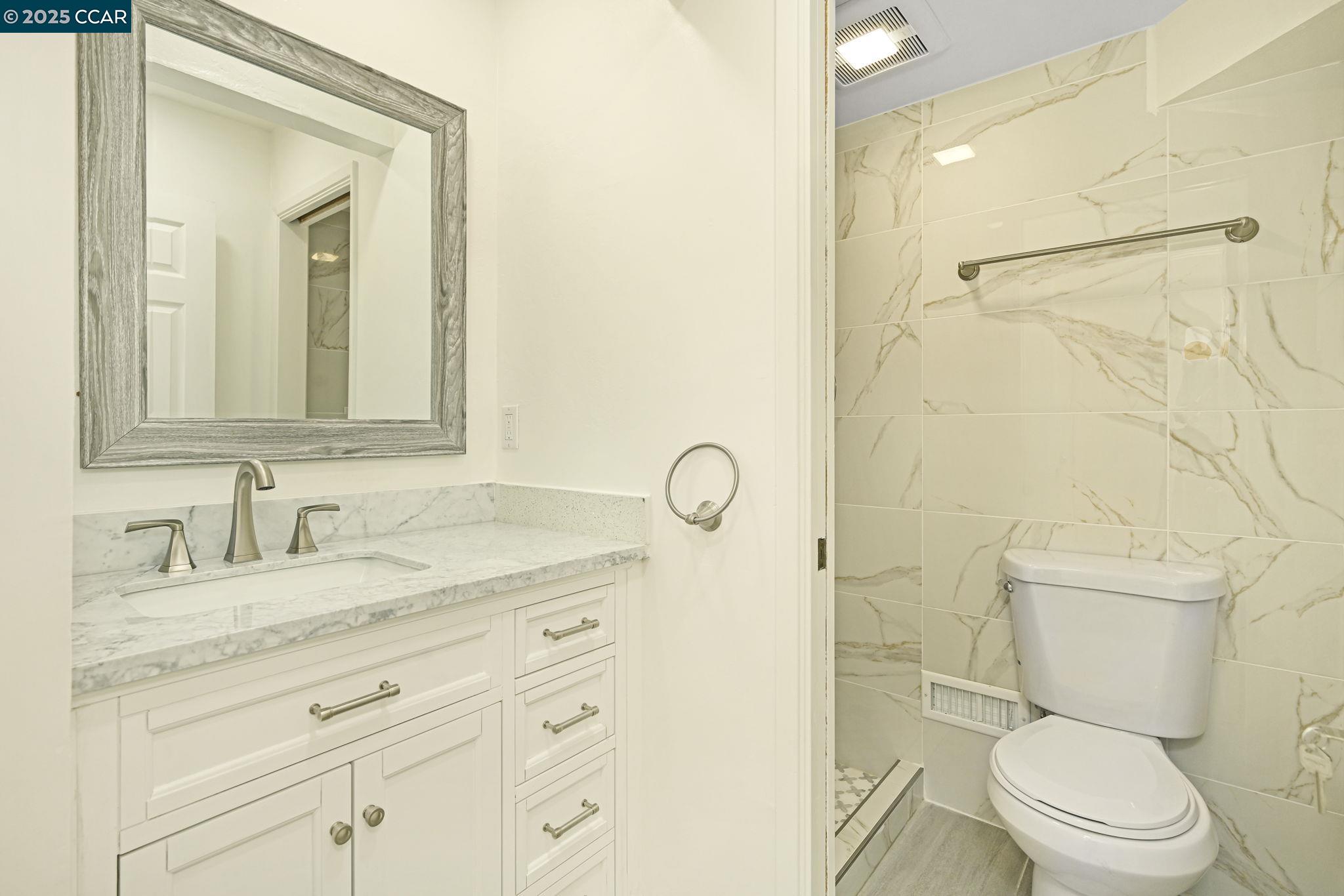 1181 Sunlight Circle Concord, CA 94518 - Photo 20 of 36 a bathroom with a granite countertop sink a toilet and a mirror