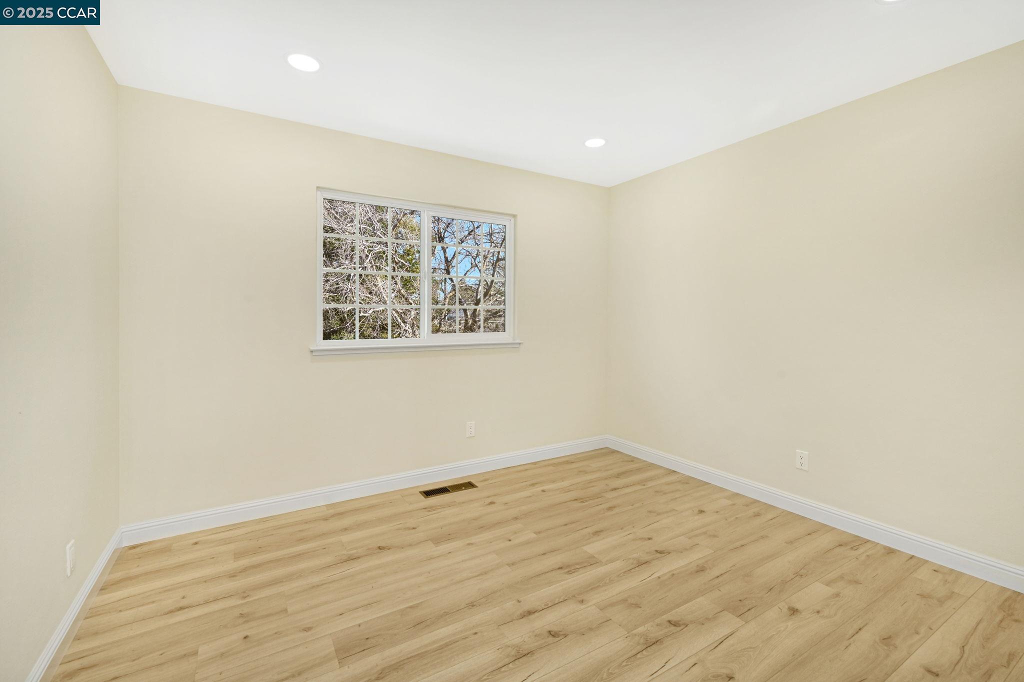 1181 Sunlight Circle Concord, CA 94518 - Photo 21 of 36 an empty room with wooden floor and windows