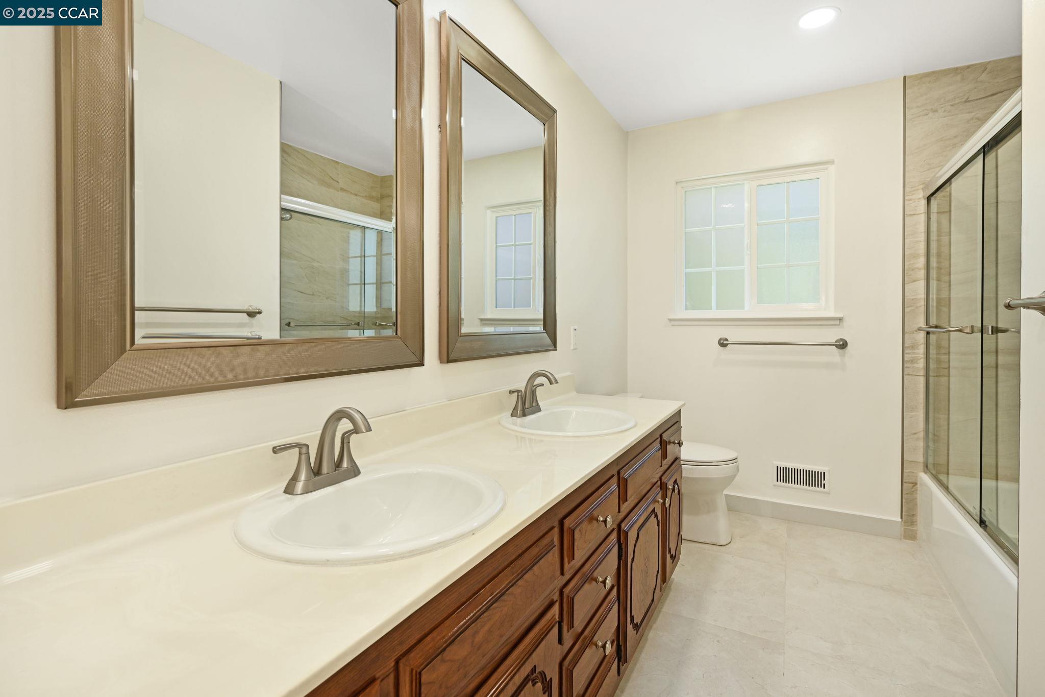 1181 Sunlight Circle Concord, CA 94518 - Photo 22 of 36 a bathroom with a double vanity sink a mirror and a shower