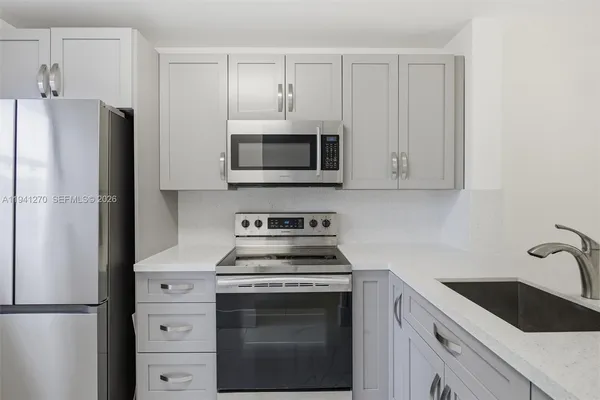 a kitchen with cabinets stainless steel appliances and a counter space