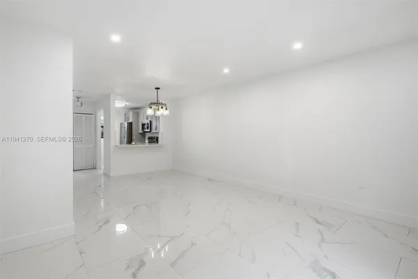 a view of a big room with wooden floor and windows