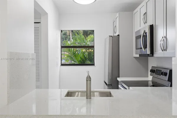 a kitchen with stainless steel appliances granite countertop a refrigerator and a sink