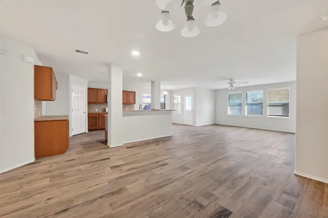 wooden floor in an empty room with a kitchen
