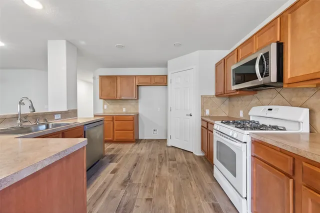 a kitchen with stainless steel appliances granite countertop a stove a sink and a microwave