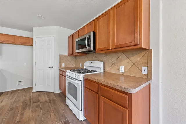 a kitchen with stainless steel appliances granite countertop a stove a sink and a microwave