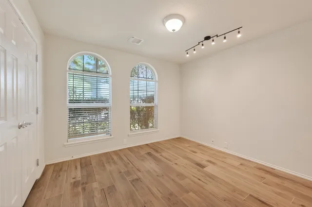 a view of an empty room with wooden floor