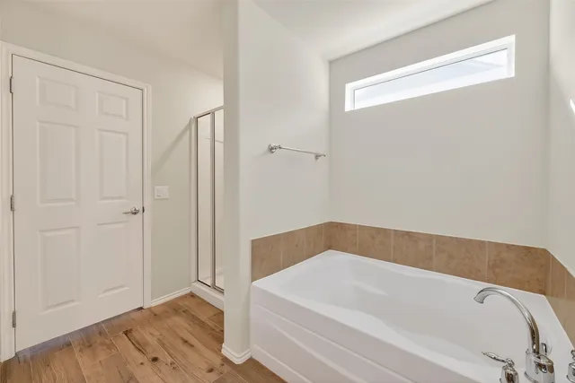 a spacious bathroom with a bathtub sink and mirror