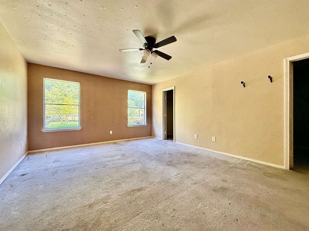 1144 Switchgrass Lane Crowley, TX 76036 - Photo 5 of 17 an empty room with windows and ceiling fan