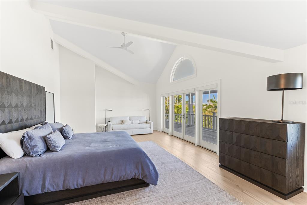 4070 Loomis Avenue Boca Grande, FL 33921 - Photo 32 of 59 a bedroom with a balcony a bed and a chandelier