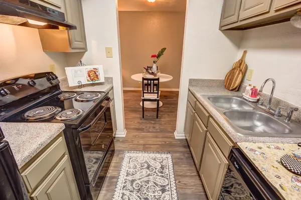 a kitchen with sink stove and cabinets