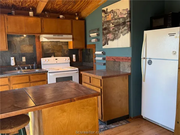 a kitchen with a sink a stove and cabinets