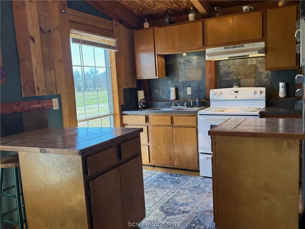 a view of a kitchen with wooden floor and a refrigerator