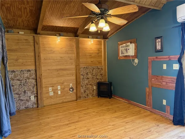 a view of a room with wooden floor and a ceiling fan