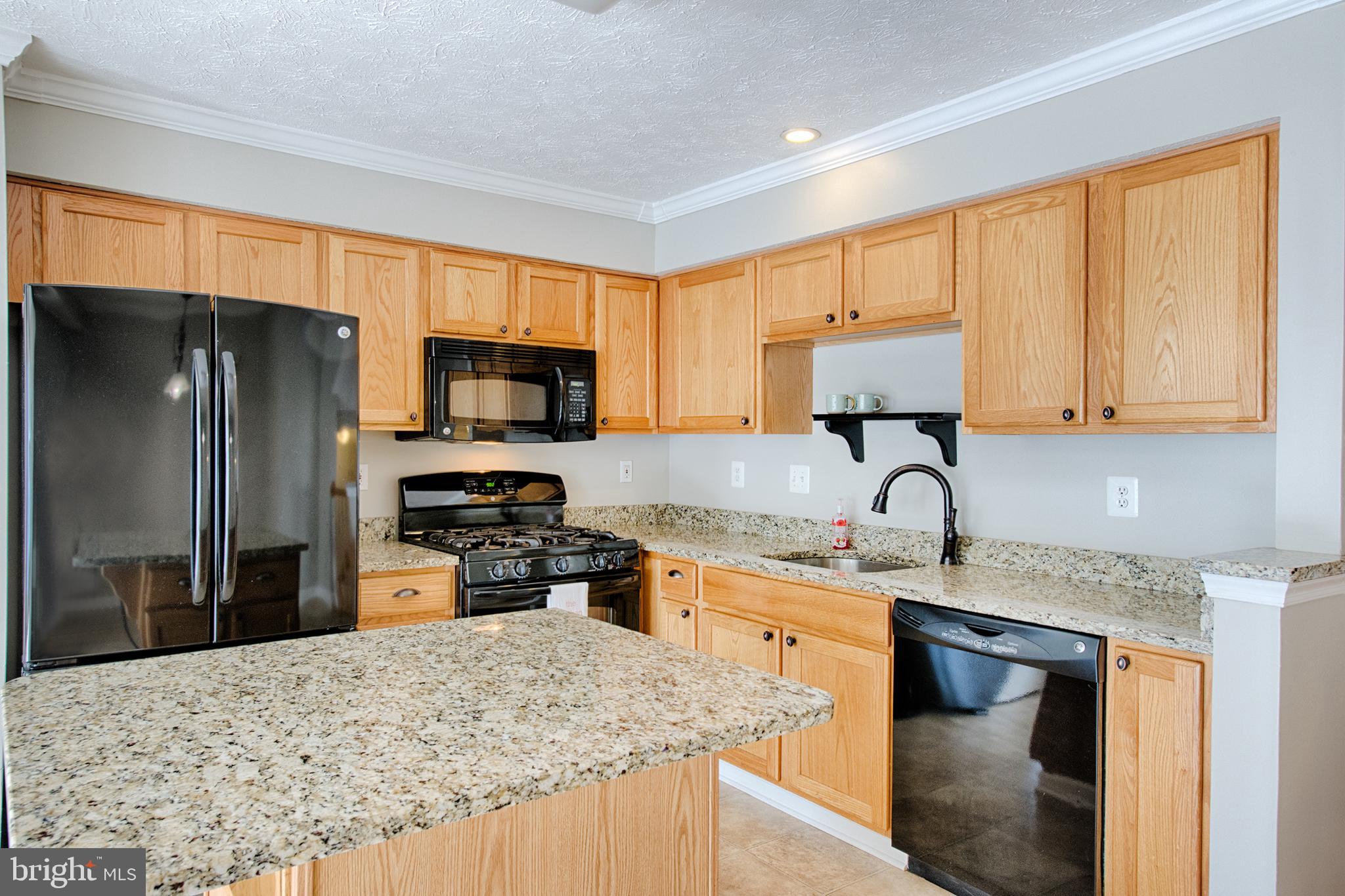 9817 Finsbury Road Baltimore, MD 21237 - Photo 9 of 36 Oak cabinets, clean black appl'cs & updated faucet
