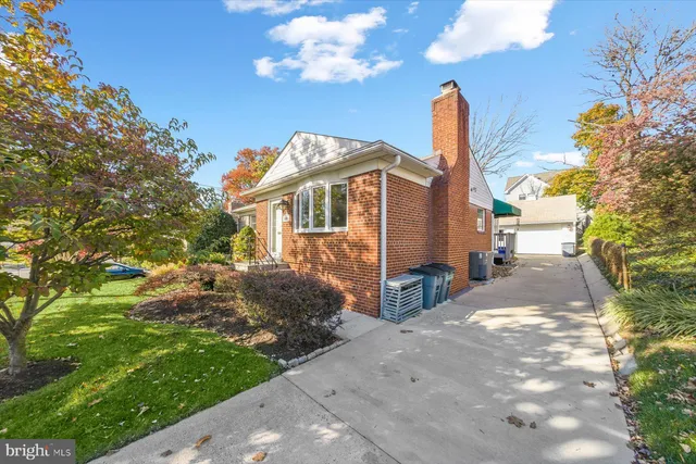 a view of a house with a small yard and a tree