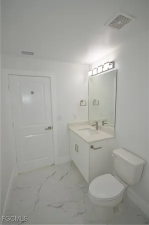 a bathroom with a toilet a sink and mirror