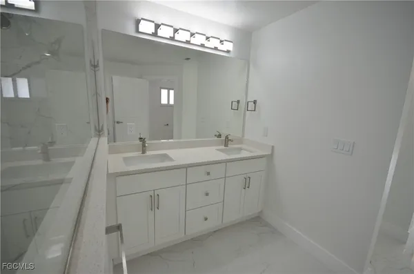 a bathroom with double sink and a mirror