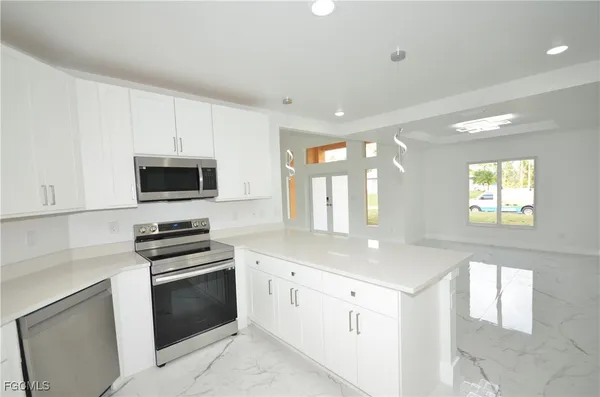 a kitchen with granite countertop white cabinets and appliances