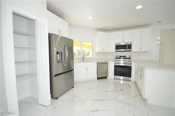 a kitchen with stainless steel appliances a refrigerator sink and microwave