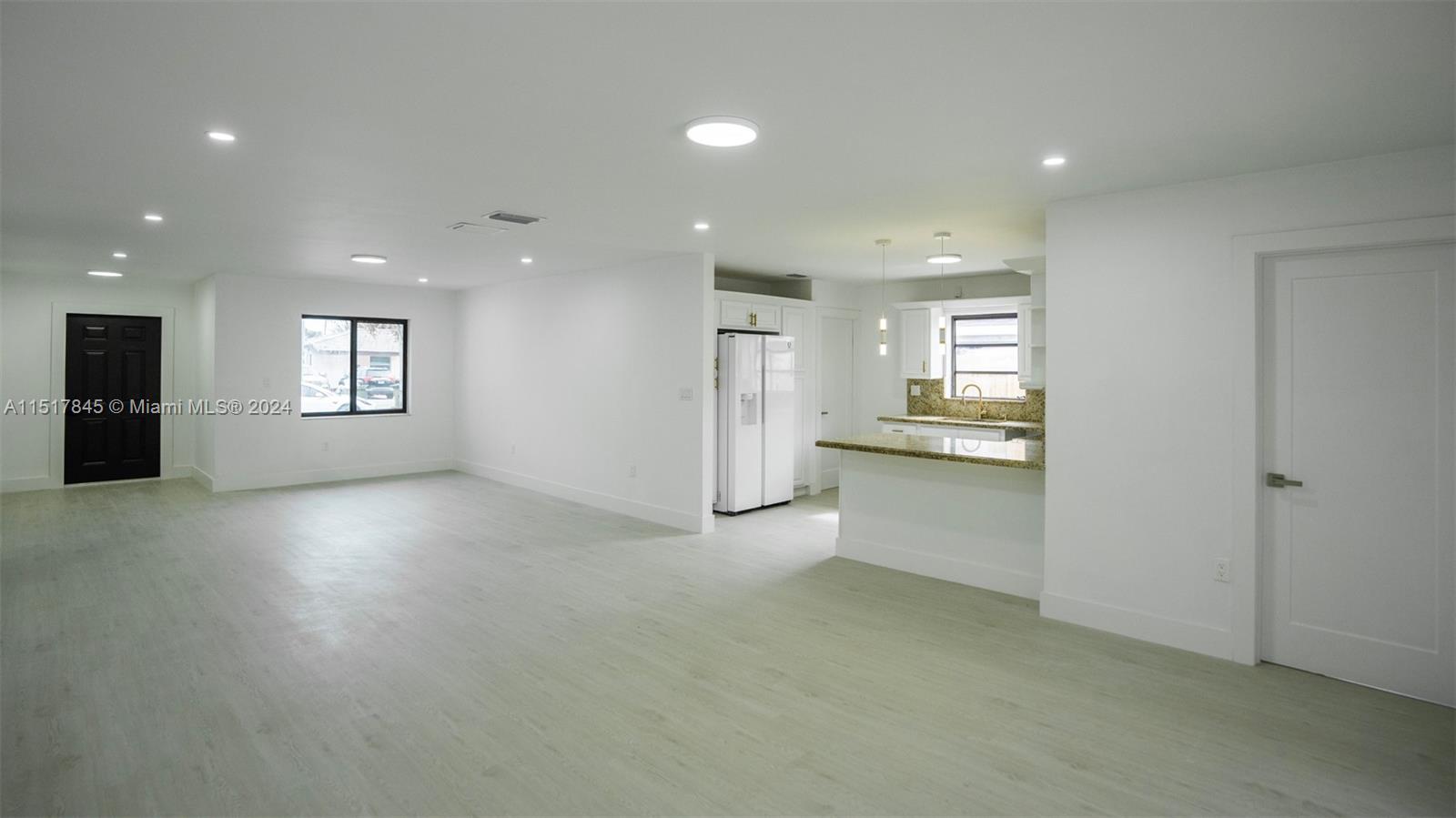 320 Southwest 66th Avenue Miami, FL 33144 - Photo 5 of 24 a view of an empty room and a kitchen with windows