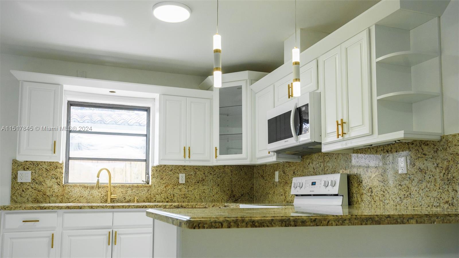 320 Southwest 66th Avenue Miami, FL 33144 - Photo 10 of 24 a kitchen with stainless steel appliances granite countertop a sink a stove and a microwave
