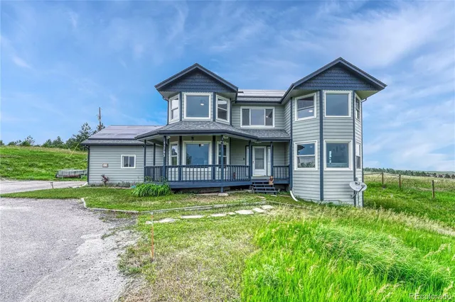 a view of a house with a big yard and large trees