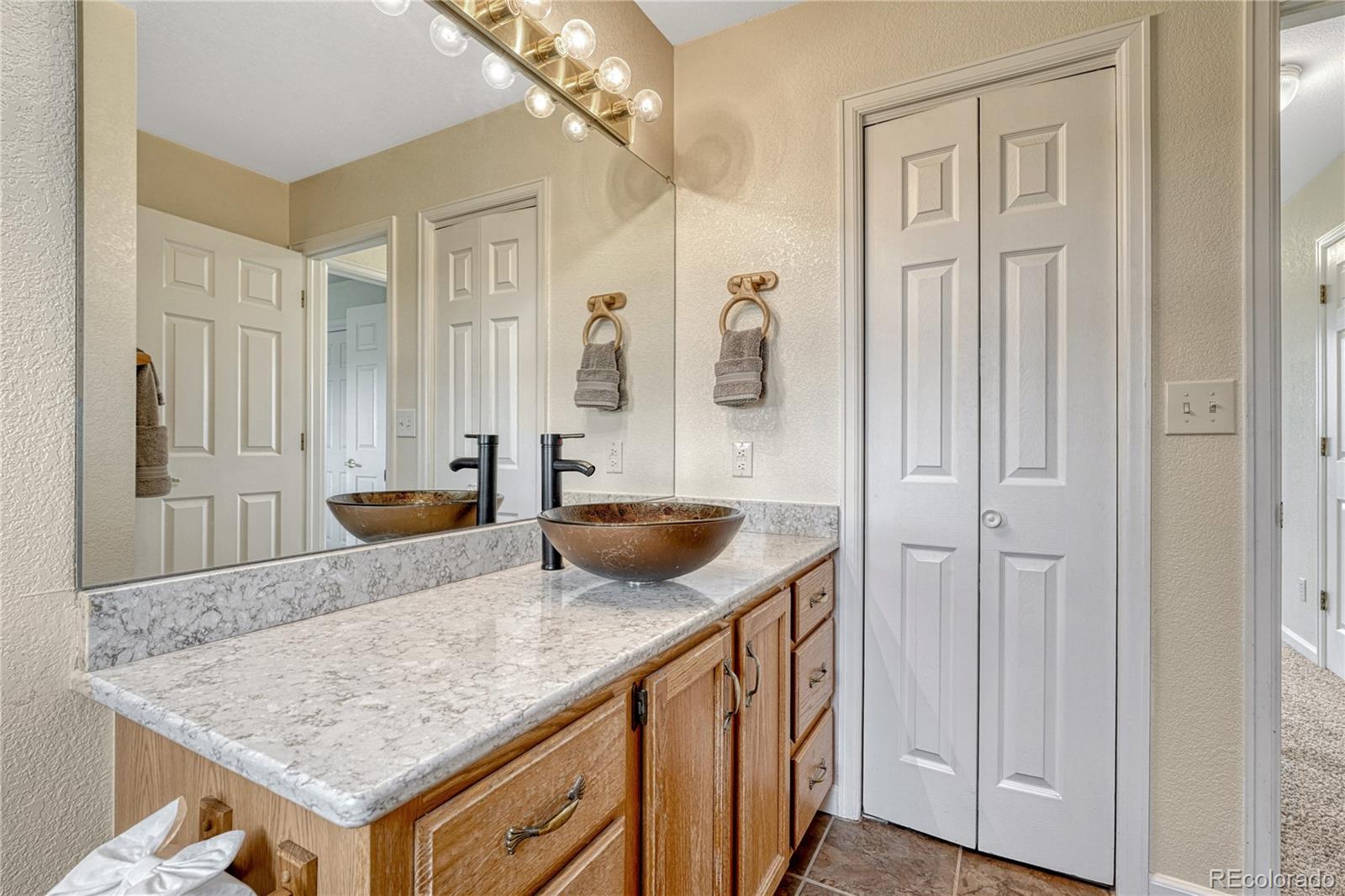 43793 Buckskin Road Parker, CO 80138 - Photo 31 of 50 a view of kitchen island wooden cabinets and living room