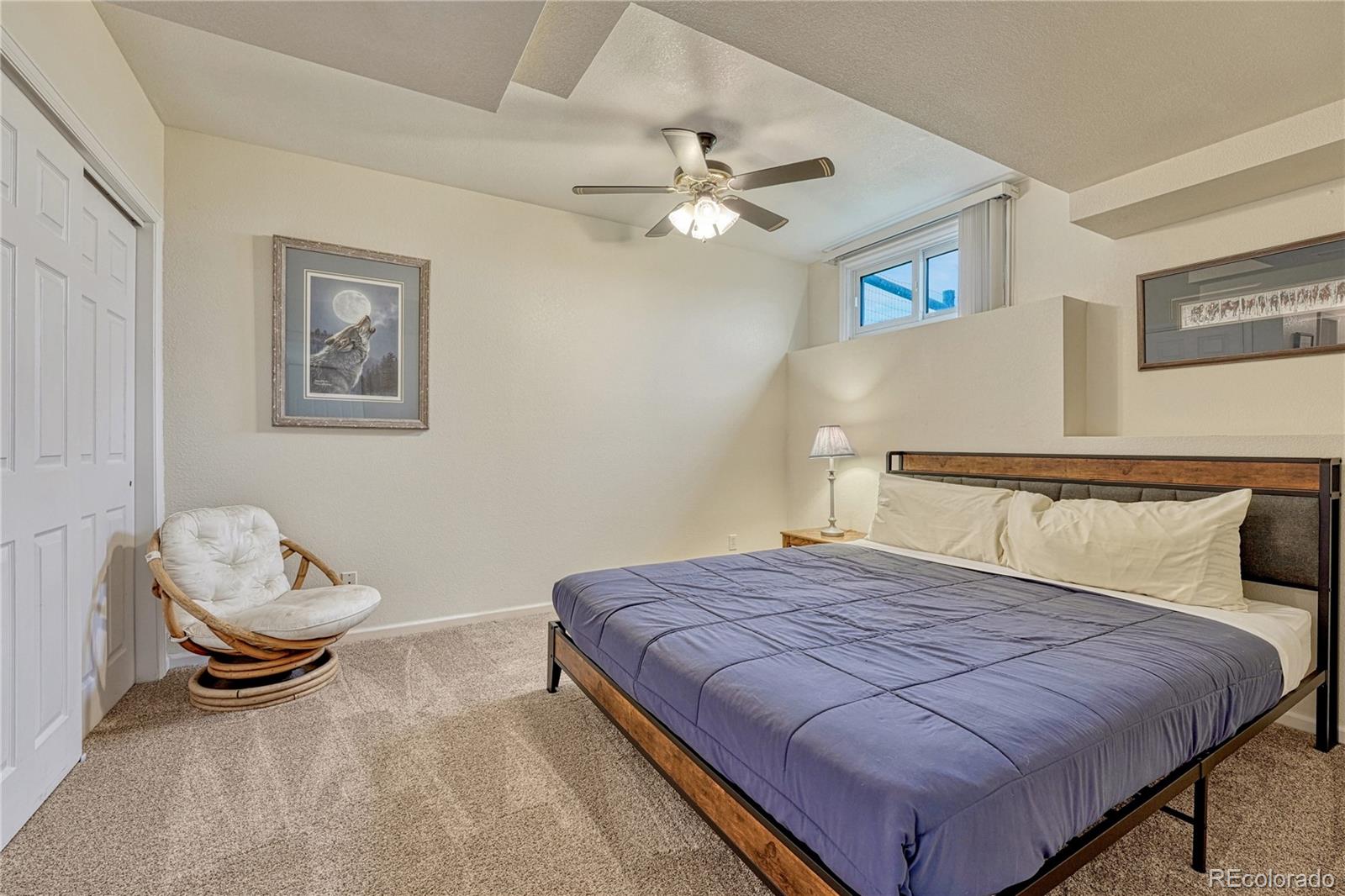 43793 Buckskin Road Parker, CO 80138 - Photo 36 of 50 a bedroom with a bed and a chandelier