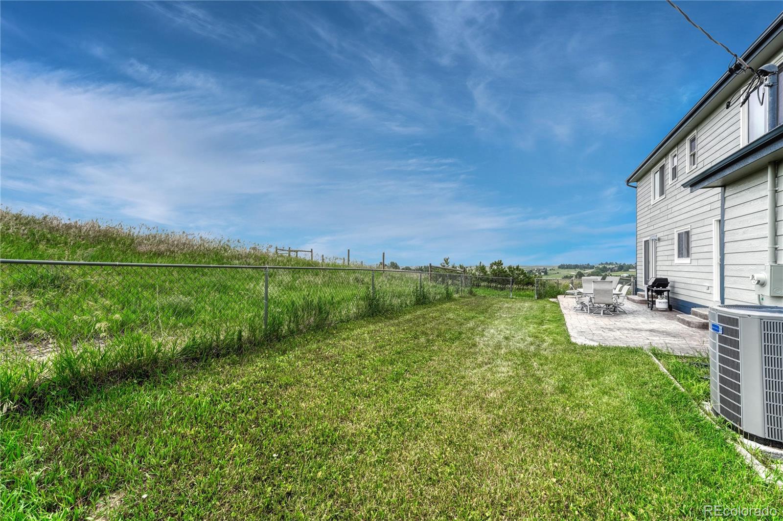 43793 Buckskin Road Parker, CO 80138 - Photo 40 of 50 a view of a backyard with lawn chairs and a large tree