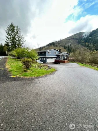 a car parked in front of a house with a big yard