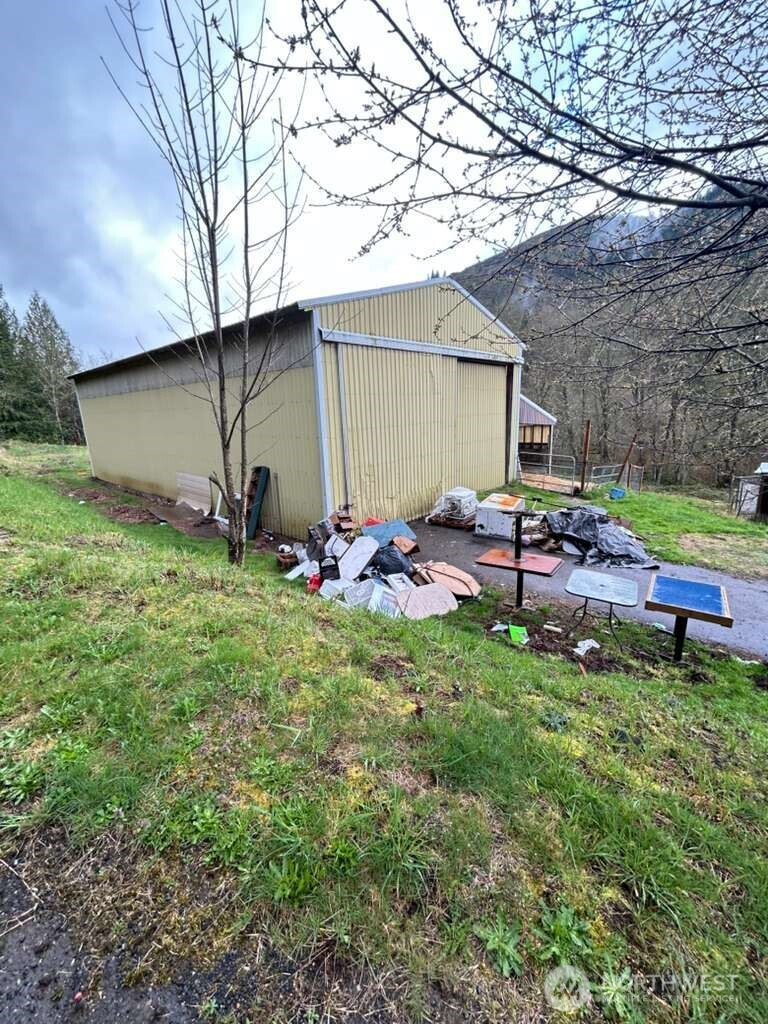 431 Highland Valley Road Morton, WA 98356 - Photo 11 of 34 a backyard of a house with barbeque oven table and chairs