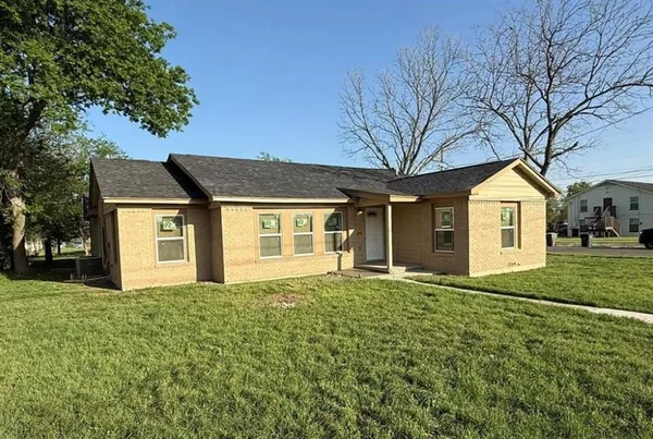 a front view of a house with yard and trees