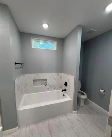 a bathroom with a bathtub and toilet